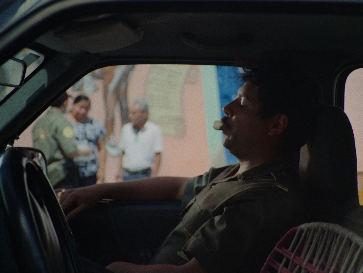 Policeman is waiting in the car while the other policeman police asking somebody on the street about the missing girl.