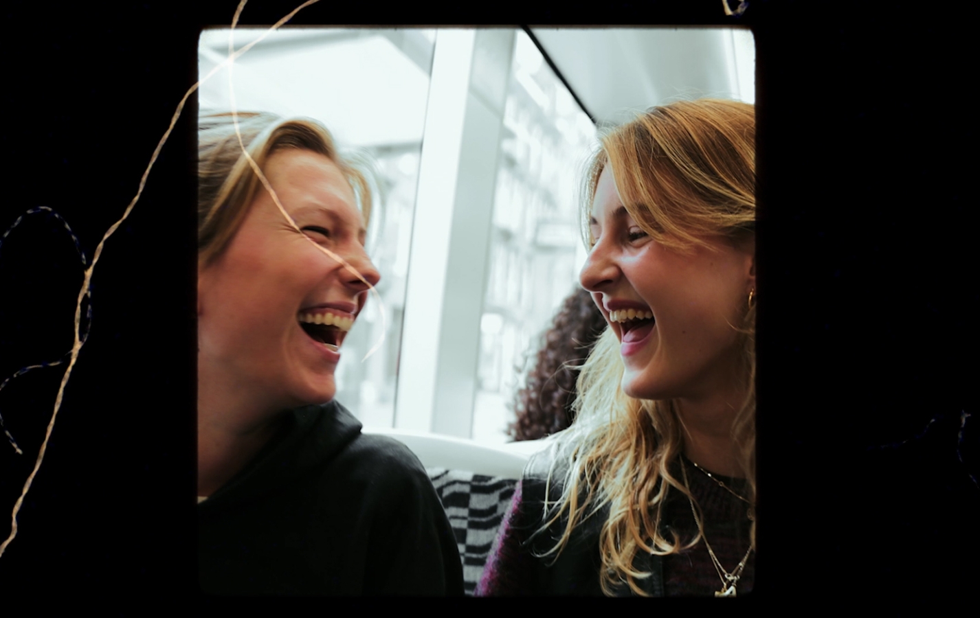 Two young women laughing at each other.