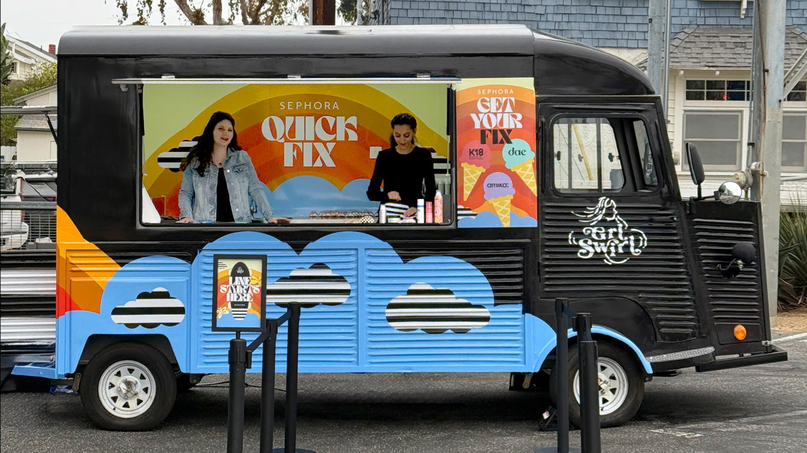 The photo features a colorful Sephora-branded food truck promoting "Quick Fix" services, with two women working at the counter. The design includes vibrant graphics with clouds and a decorative sign, creating a lively atmosphere in an outdoor setting.