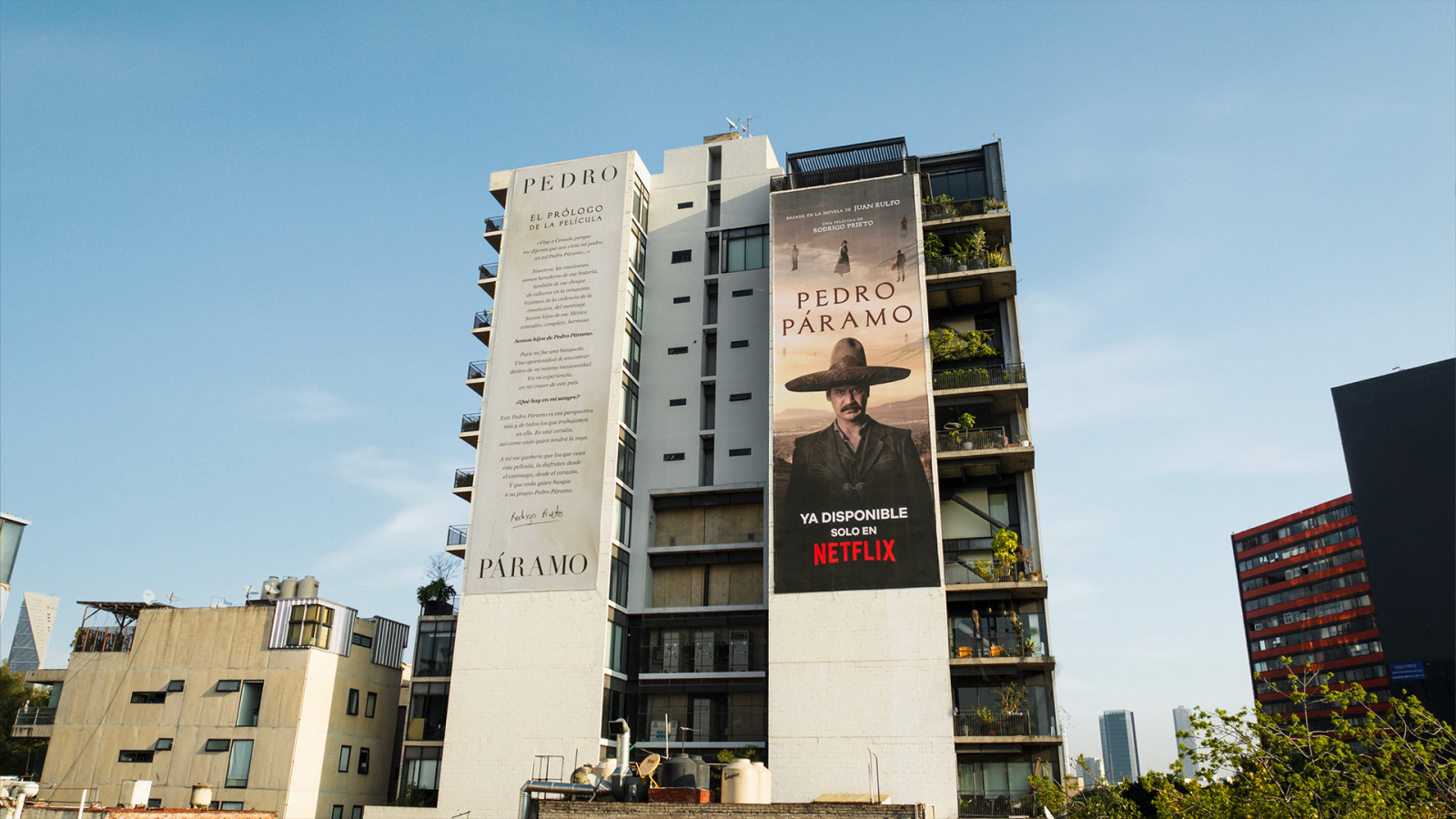The image shows two large billboards on a building promoting "Pedro Páramo," one providing a prologue text and the other displaying a character from the film, with a notice that it is available on Netflix.