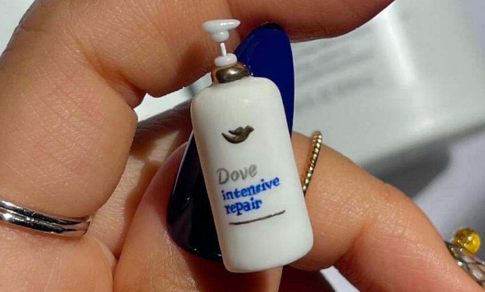 A hand-made miniature Dove Hair product affixed to the blue thumbnail of an influencer.